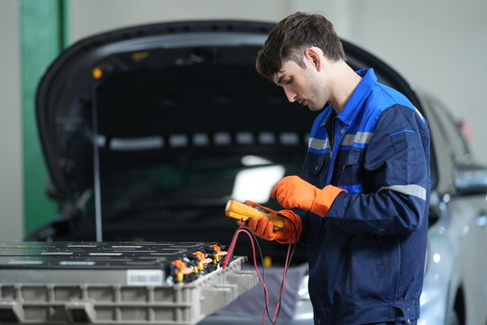 EV Technician Performing High Voltage Battery Diagnostics with Digital Multimeter in Electric Vehicle Service Center