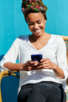 Young woman smiling while texting on smartphone