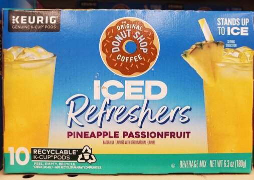 Pittsburgh, Pennsylvania, U.S.A - Jul 18, 2026 - Keurig K-Cup box for Donut Shop Iced Refreshers Pineapple Passionfruit featuring tropical drink imagery and recyclable packaging.