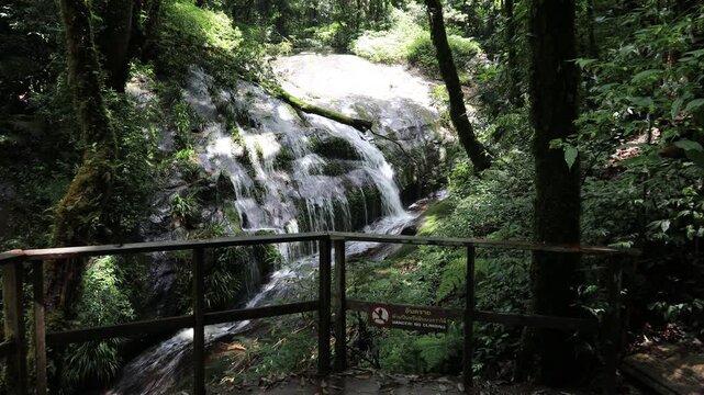 The video features a stunning natural backdrop of a waterfall in Chiang Mai, located on the summit of Doi Inthanon, a popular destination for travelers from around the world.