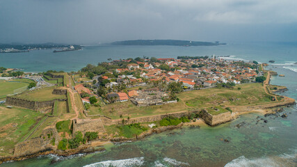Fototapeta premium Frames of heritage capturing the ancient clock tower and historic fortress walls of Galle against a clear blue sky.
