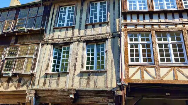 Charming half-timbered house facade showcasing intricate woodwork and several windows. Ideal for articles about Europe, history, and travel
