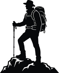 Silhouette of a hiker with a backpack standing on a mountain peak looking at view