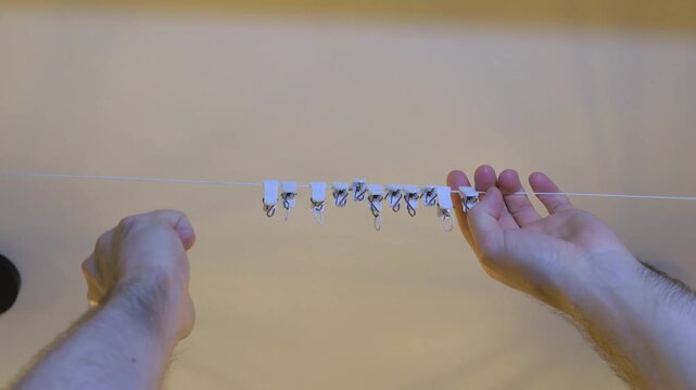 Remove the clothes pegs from the line after taking the washed laundry down. Clothes pegs.