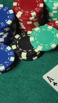 Colorful poker chips are stacked on a green felt table, with the ace of clubs card partially visible, creating a vibrant scene that captures the essence of a card game environment