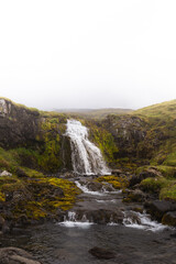 Freshwater cascades over mossy basalt rocks in West Iceland © Fauren