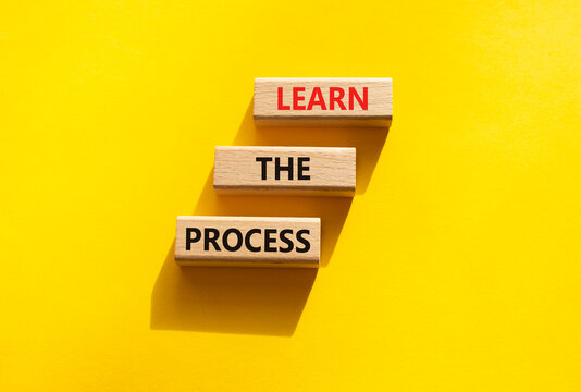 Learn the process symbol. Concept words learn the process on wooden blocks arranged as steps. Learning and development concept. Yellow background. Copy space.