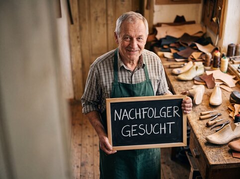 Schuhmacher h&auml;lt Tafel Nachfolger gesucht in Werkstatt