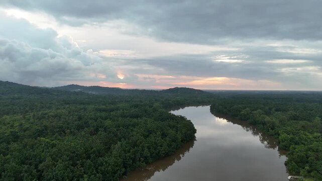 Aerial drone footage showing a tropical river surrounded by dense rainforest near Roura in French Guiana during evening light.