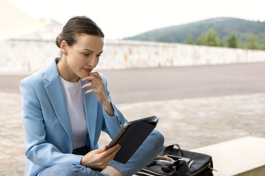 Businesswoman looking at tablet screen, working on her business remotely and thinking. copy space