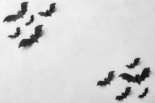 halloween decoration concept - black bats on white concrete background