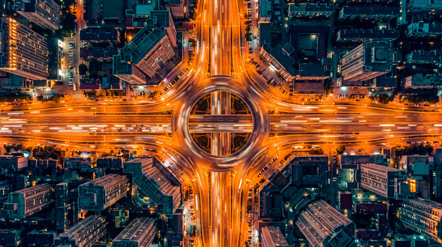 Aerial Night View of a Symmetrical Urban Highway Interchange with Light Trails