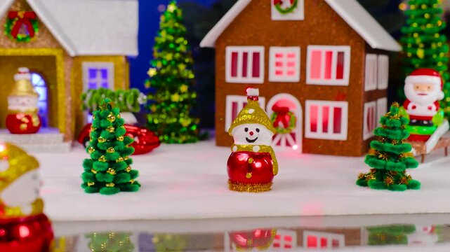 In the center of a small Christmas town there are snowmen and small Christmas trees