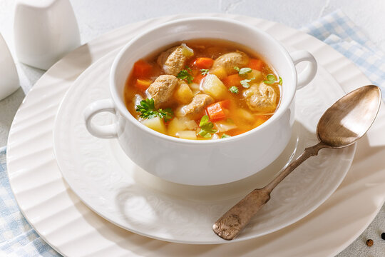 Old fashioned poultry meatball soup in clear broth