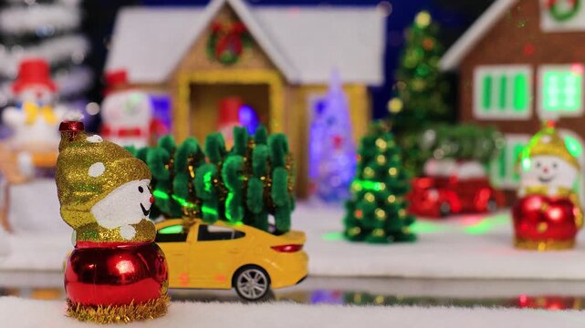 A yellow car drives up to a snowman against the backdrop of a small Christmas town