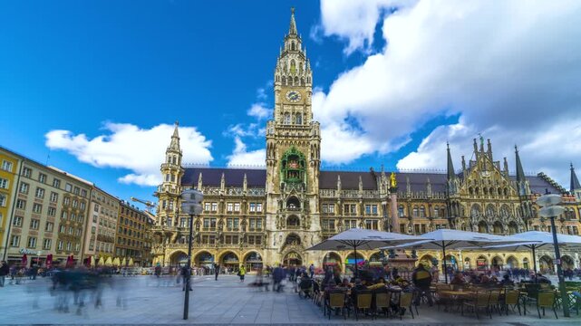 Hyperlapse of the New Town Hall at Marienplatz showcasing magnificent Gothic Revival architecture under a bright blue sky in the heart of Munich, Bavaria, Germany.