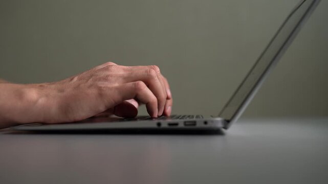 Hands of businessman or programmer typing code on laptop keyboard. Concept of concept of remote work, freelancing, online education, writing important email from home office. Shooting in slow motion.