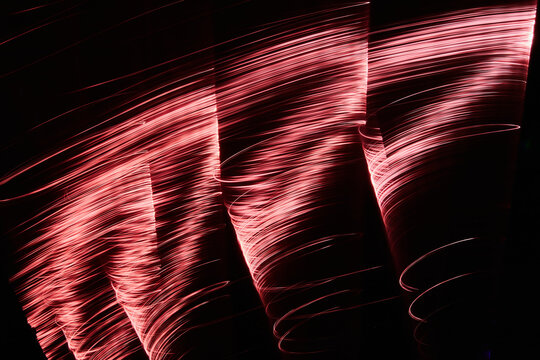 Abstract red light streaks creating dynamic pattern on black background, expressing speed and energy