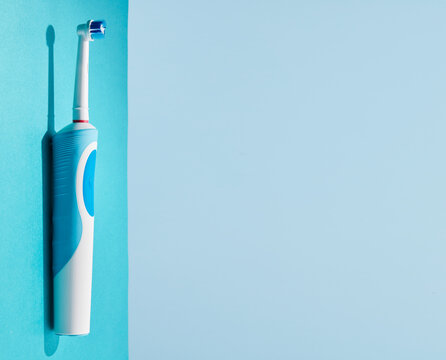 Electric toothbrush on a blue background. Modern technologies for health. Healthy teeth. A modern tool for daily oral care.