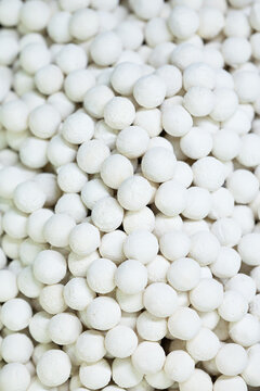 Background texture of traditional dried white kurt cheese balls. Organic dairy snack prepared for central asian cuisine, wholesale supply, and retail grocery market.