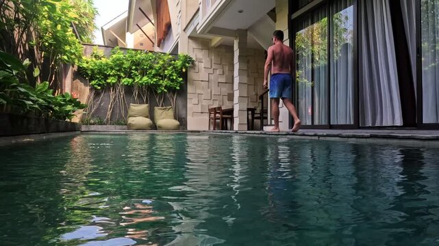 Man entering private swimming pool at luxury villa