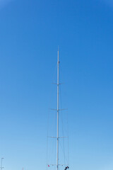Obraz premium Sailboat mast and rigging reaching blue sky