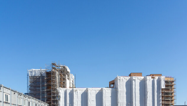 Building facades covered with white sheeting for construction in Oslo