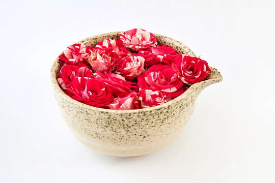 Ceramic bowl filling with vibrant red and white roses