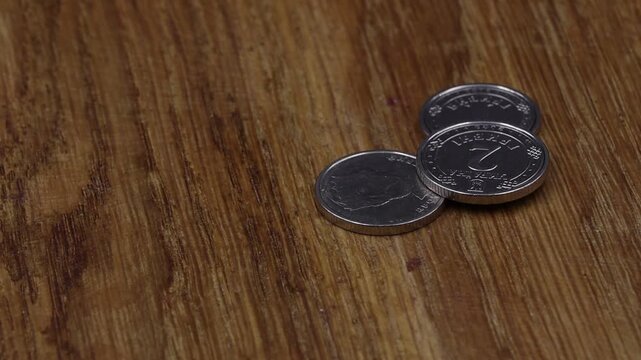 Ukrainian hryvnia coins rotating on a wooden turntable close-up. Ideal for finance, economy, banking, or historical projects.