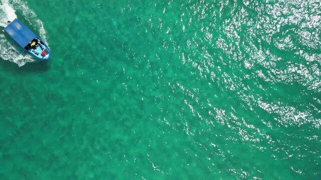 Aerial drone shot of a traditional local panga boat speeding through the beautiful waves and stunning turquoise waters of Cabo Pulmo, coastal tourism and travel
