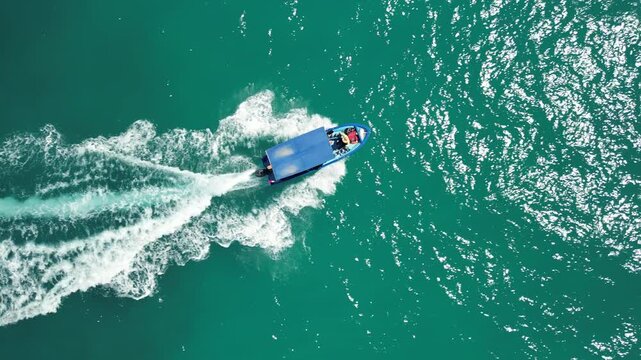 Aerial drone shot of a traditional local panga boat speeding through the beautiful waves and stunning turquoise waters of Cabo Pulmo, coastal tourism and travel
