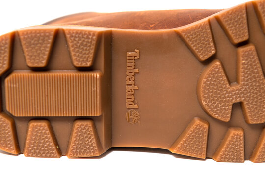Timberland logo appears embossed within a rugged brown rubber boot outsole.