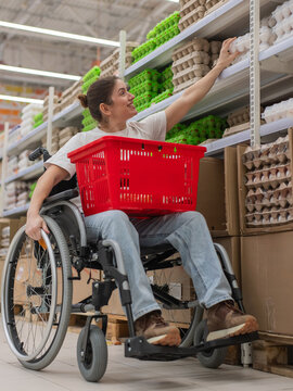 A Caucasian woman in a wheelchair shopping in a supermarket.
