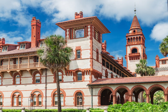 Flagler College tower and arched facade rise among palms in Saint Augustine.