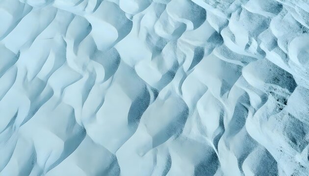 Abstract aerial view of undulating sand dunes with soft blue and white tones