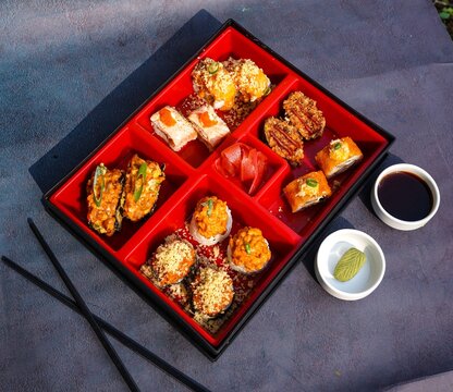 Assorted Sushi, Maki, rolls, nigiri, uramaki, hosomaki, a variety of Japanese sushi, Sushi Set sashimi and sushi rolls, long plate, fine dining, rice, fish, on a dark background, smoked eel, Japan