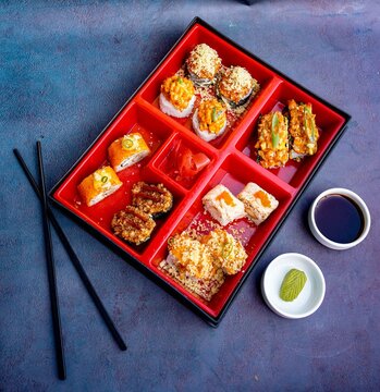 Assorted Sushi, Maki, rolls, nigiri, uramaki, hosomaki, a variety of Japanese sushi, Sushi Set sashimi and sushi rolls, long plate, fine dining, rice, fish, on a dark background, smoked eel, Japan