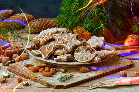 Decorated gingerbread pieces with icing details are spread across textured wood. Bright details create cheerful holiday atmosphere.