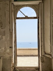 Obraz premium Historic doorway framing peaceful sea view through ancient architecture