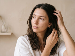 Fototapeta premium Woman Running Fingers Through Her Hair Looking Away