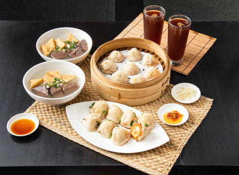 Steamed dumplings and soup set for two. Asian food meal with dim sum and iced tea drinks.