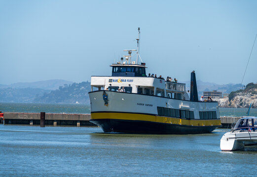 San Francisco, CA - July 15 2026: A Blue and Gold Fleet tour ferry navigates towards Pier 39, carrying passengers across the bay waters.