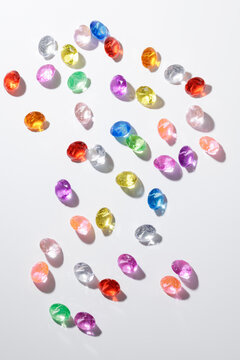 Colorful assorted gemstones sparkling on white surface in bright light, flat lay Africa continent from diamonds, concept mining kimberlite