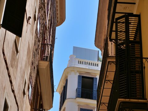 Low Angle View of Narrow European Street Facades and Clear Blue Sky