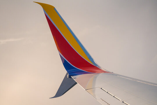 The colorful tail fin of a Southwest Airlines passenger airplane stands against a light grey sky before departure at the airport. USA, Fort Lauderdale, FL - May 18, 2026