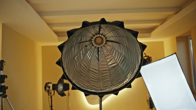 Parabolic softbox turning on in professional photo studio lighting setup.