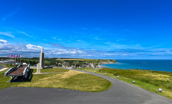 Arromanches view from Cap Manvieux, Normandy, France, with Notre-Dame des Flots statue, WWII artificial harbor remnants and original steel Whale bridge spans.