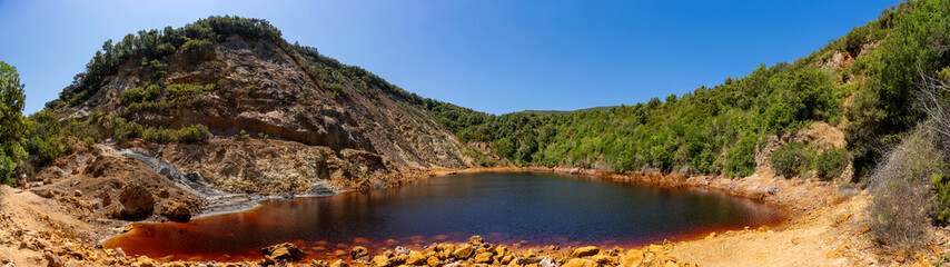 Fototapeta premium Laghetto delle conche red mineral lake featuring iron-rich water in elba island mining landscape