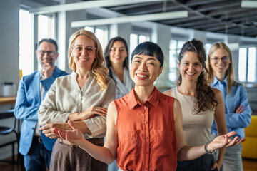 Fototapeta premium Diverse business team smiling standing together in modern office