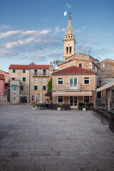 Fototapeta premium Historic church bell tower and empty square with moon in Jelsa